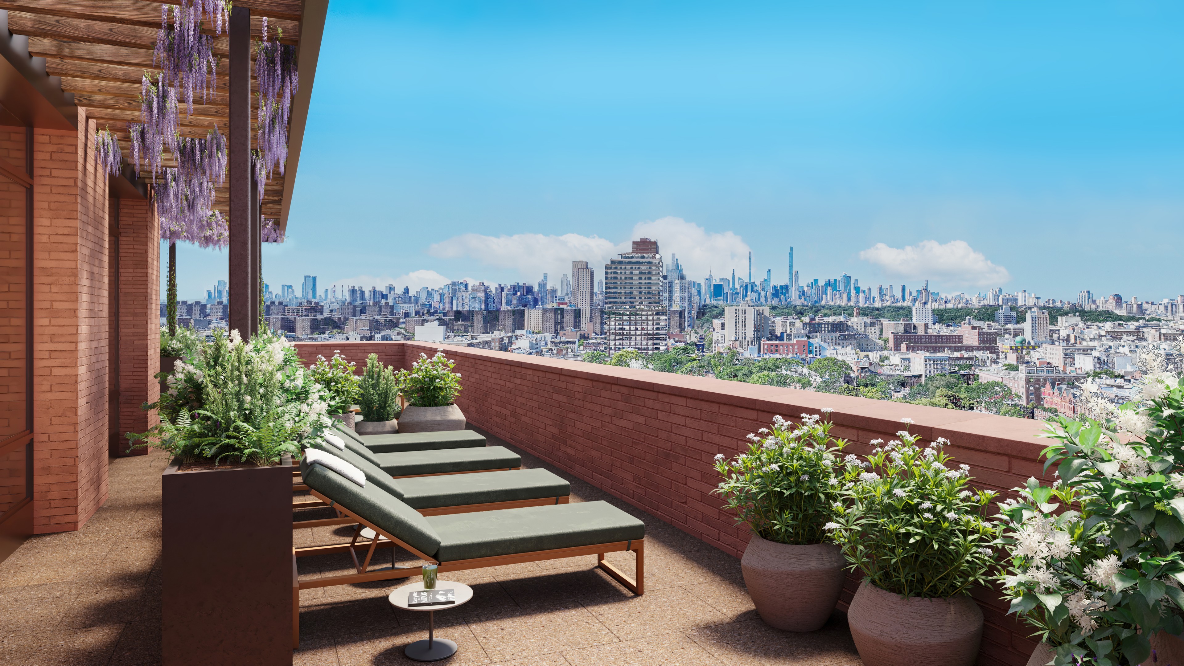 A rooftop terrace with lounge seating and outdoor kitchen at Ray Harlem, featuring panoramic views of Manhattan.