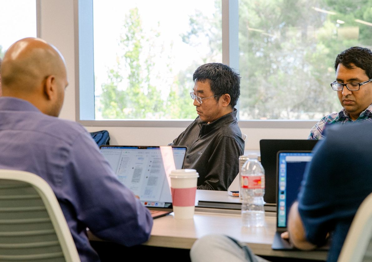 Engineers working at laptops by the window