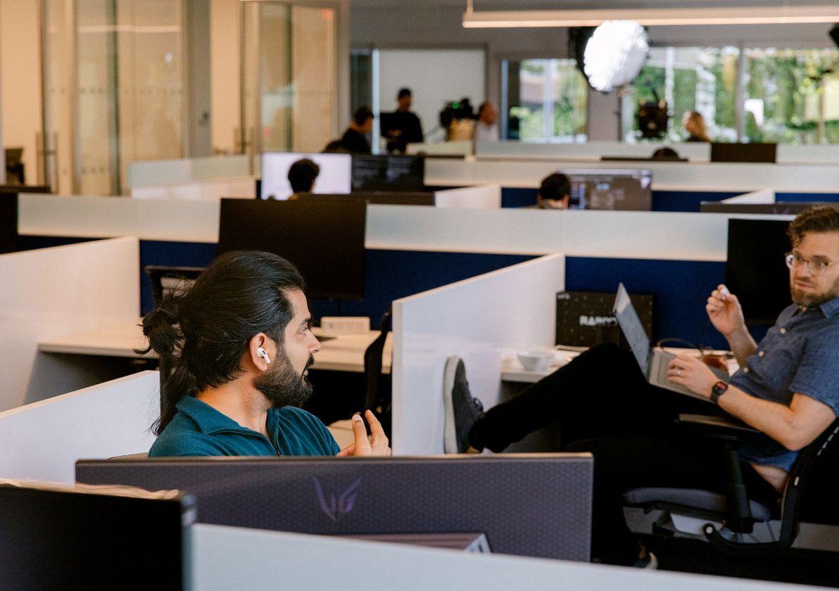 Two engineers talking across the open-plan office