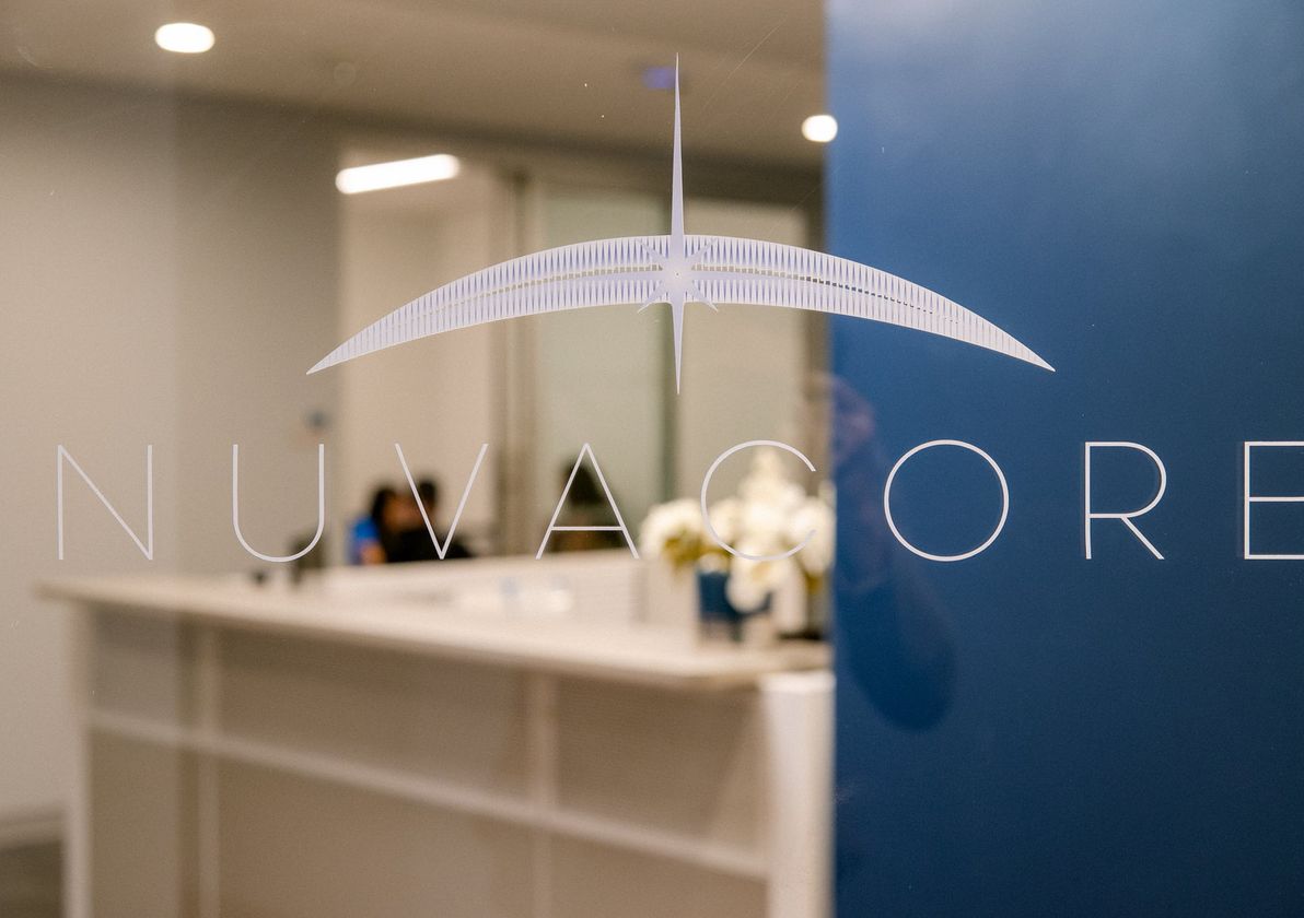 The NUVACORE mark etched on the office's glass door, reception behind it