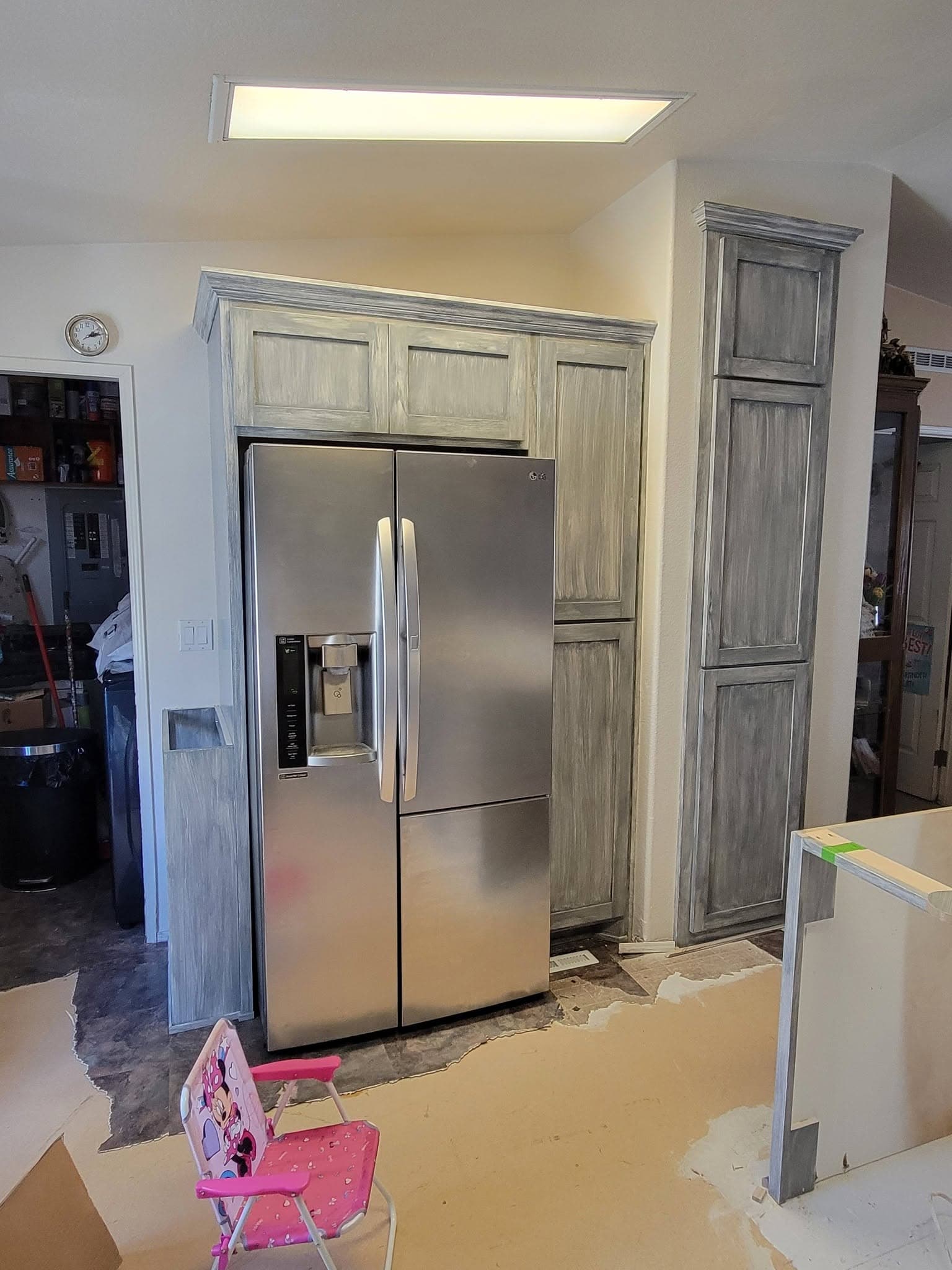 Grey distressed pantry and refrigerator surround cabinetry