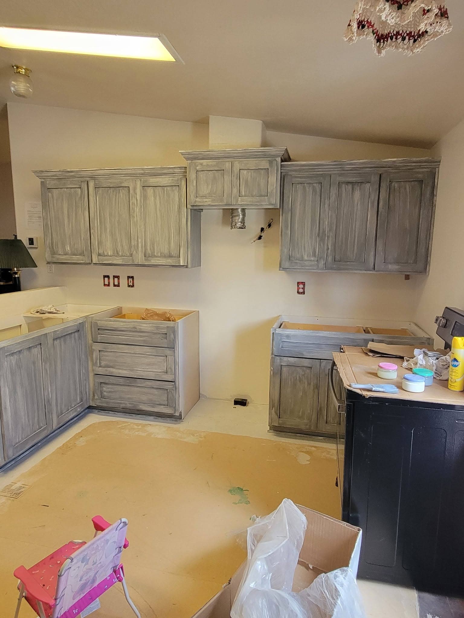Weathered grey distressed kitchen cabinetry mid-installation