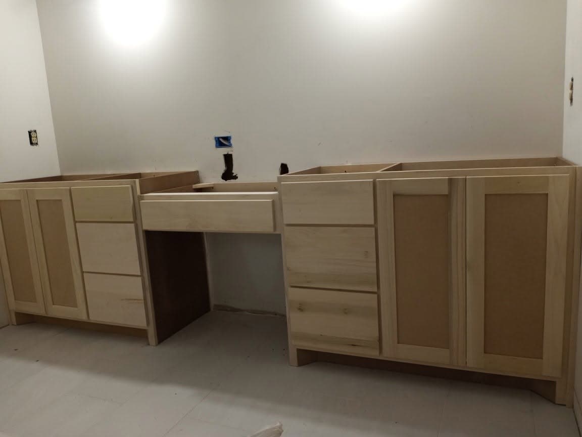 Unfinished maple office cabinets and desk during installation
