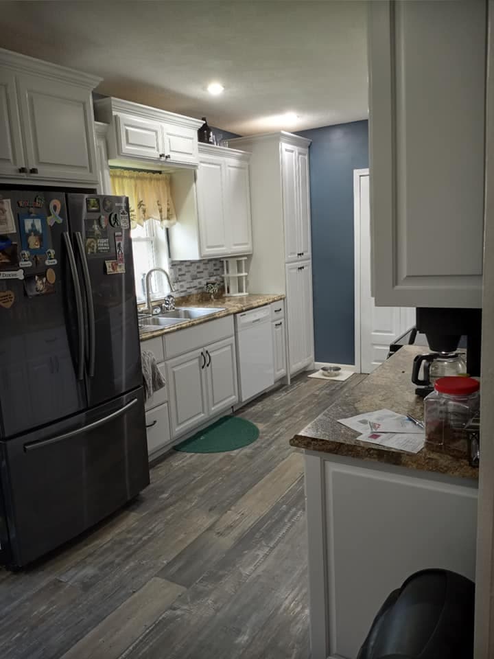 Custom kitchen with white cabinetry and dark counters