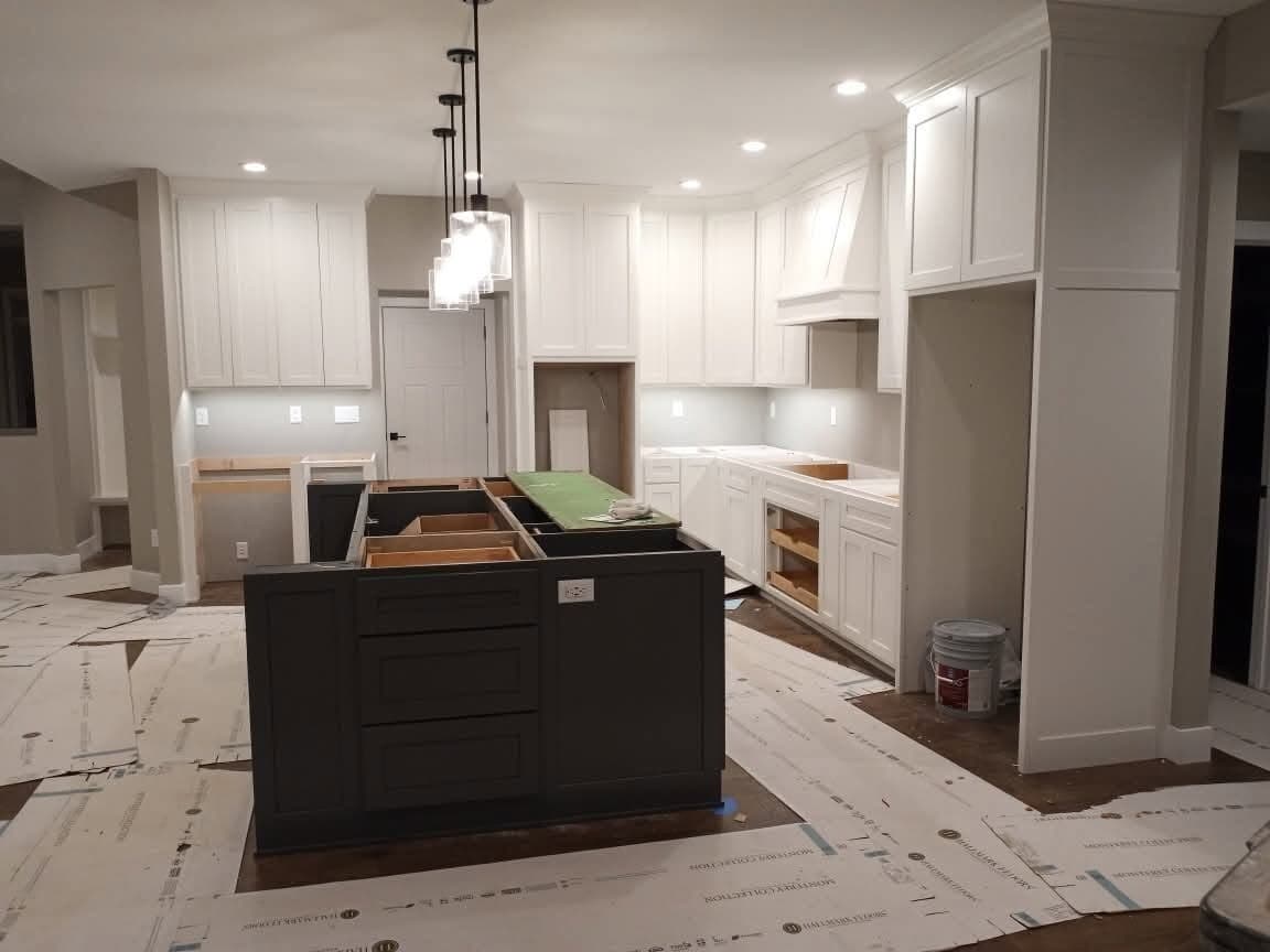 White kitchen with charcoal island during installation