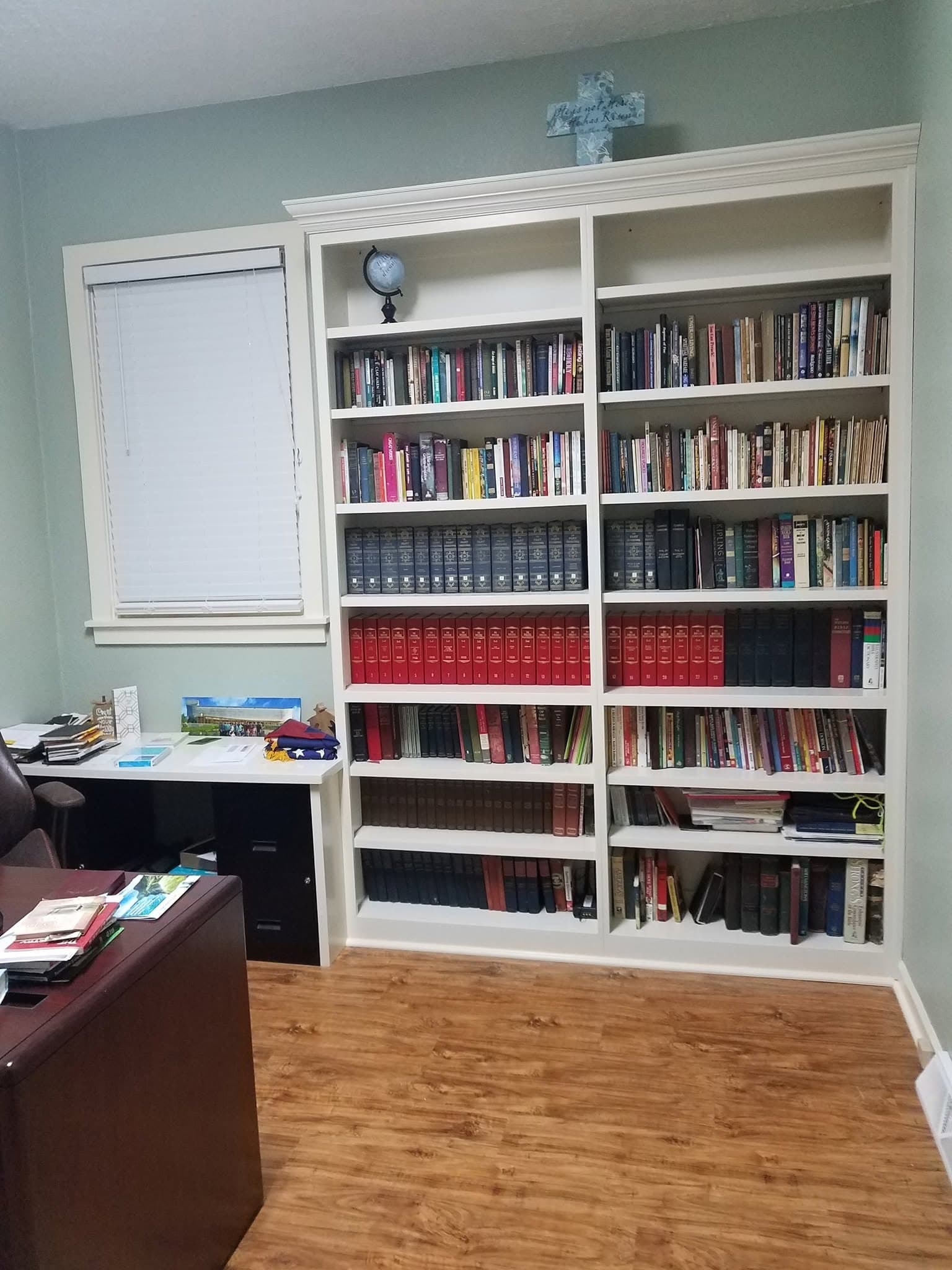 Floor-to-ceiling white built-in bookcase wall with desk
