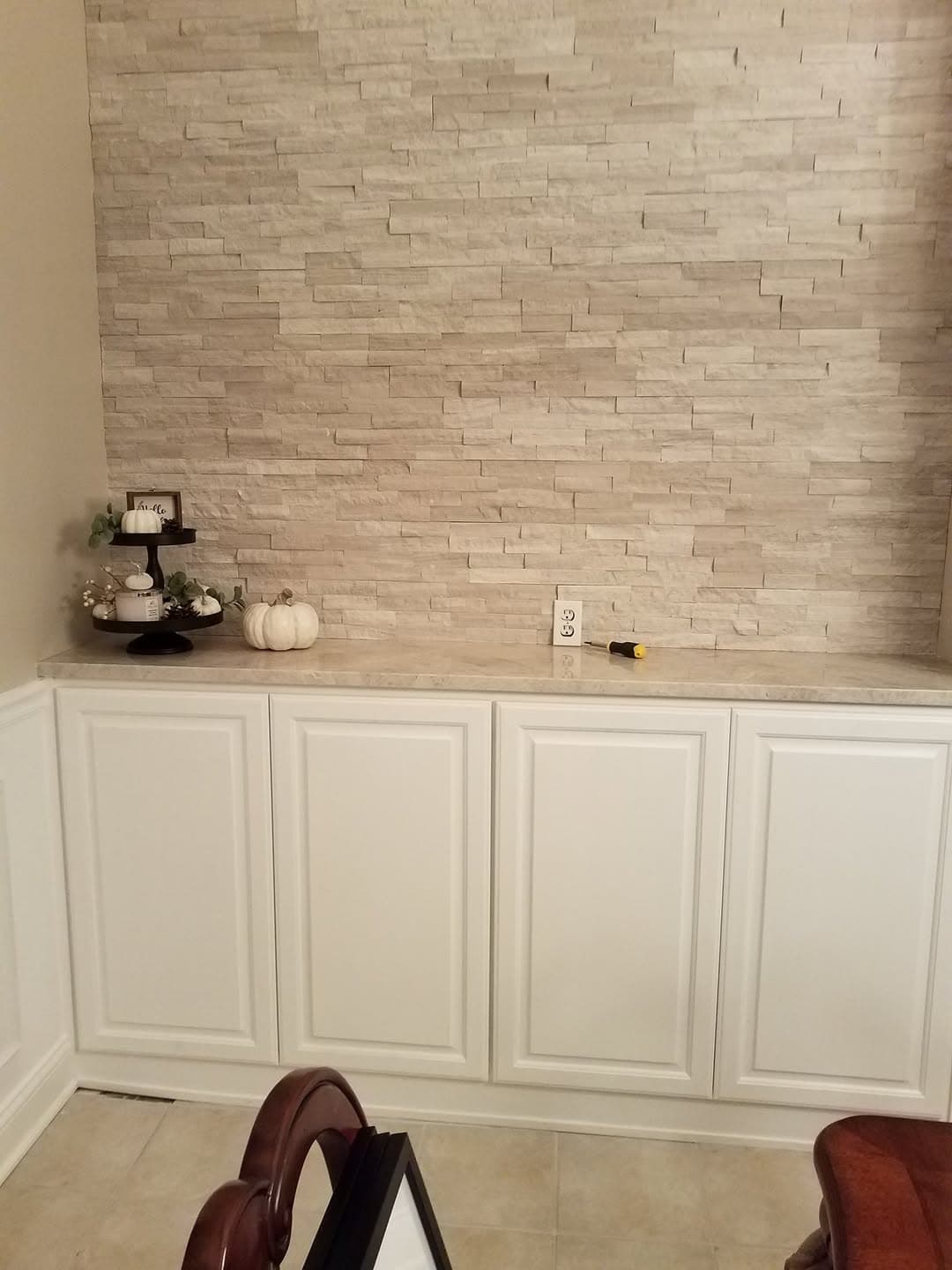 Custom white cabinetry with stone feature wall
