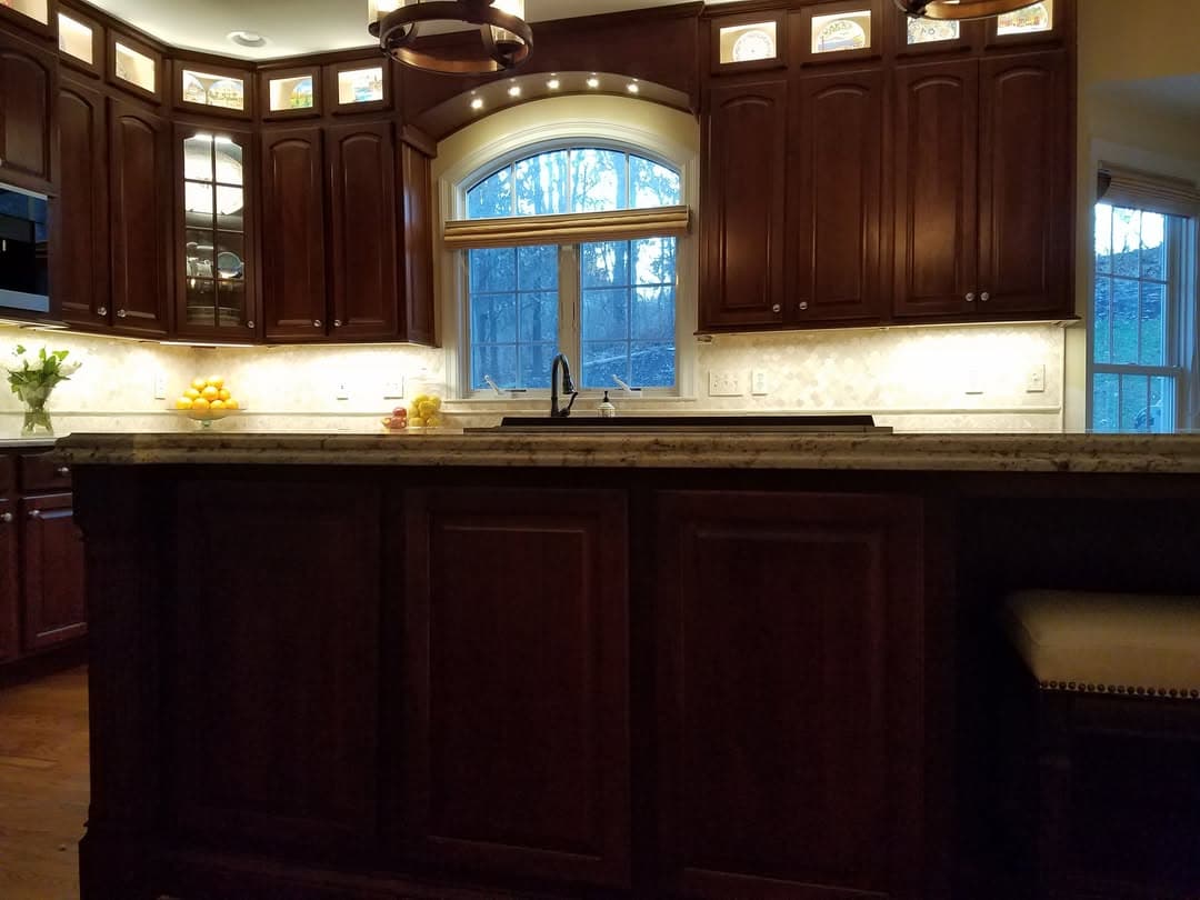 Custom cherry kitchen cabinetry and arched window