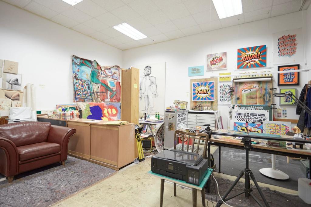 Atelier mit Bildern, Ledersofa und Arbeitstisch