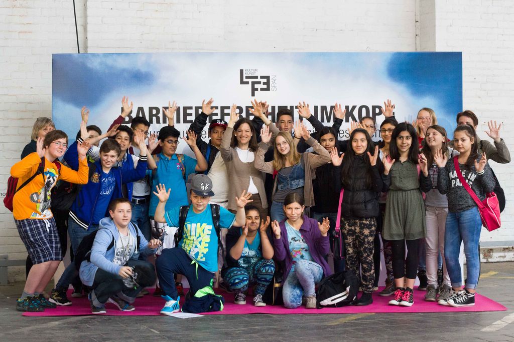 Barrierefreiheit im Kopf 2015: Eine Schulklasse winkt vor der Festivalwand „Barrierefreiheit im Kopf“