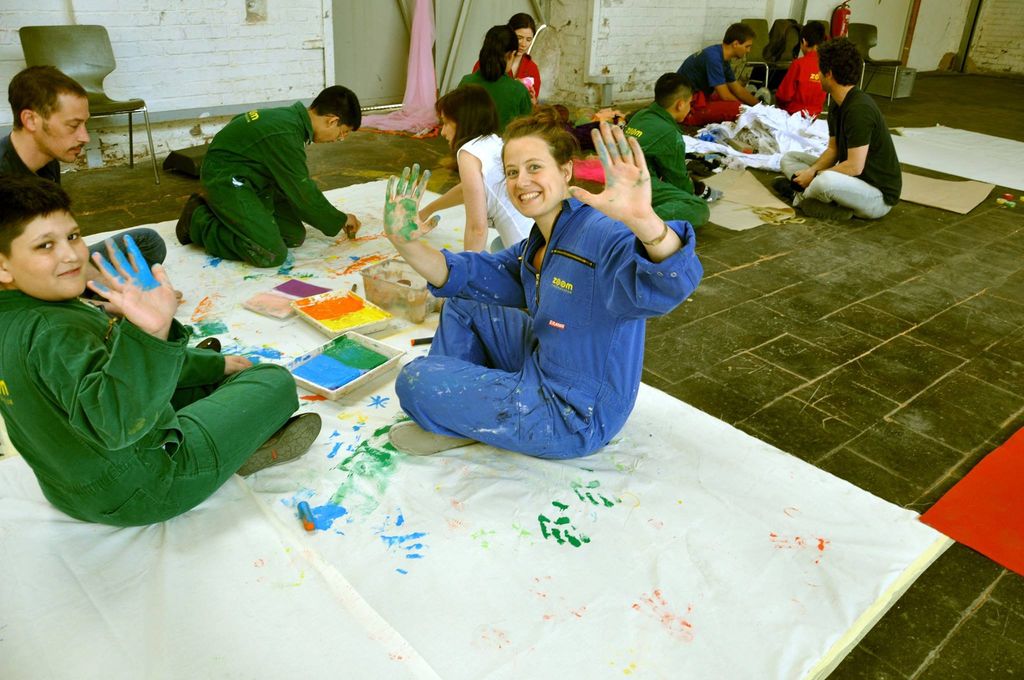 Barrierefreiheit im Kopf 2015: Malworkshop: Jugendliche in Overalls zeigen ihre farbigen Hände
