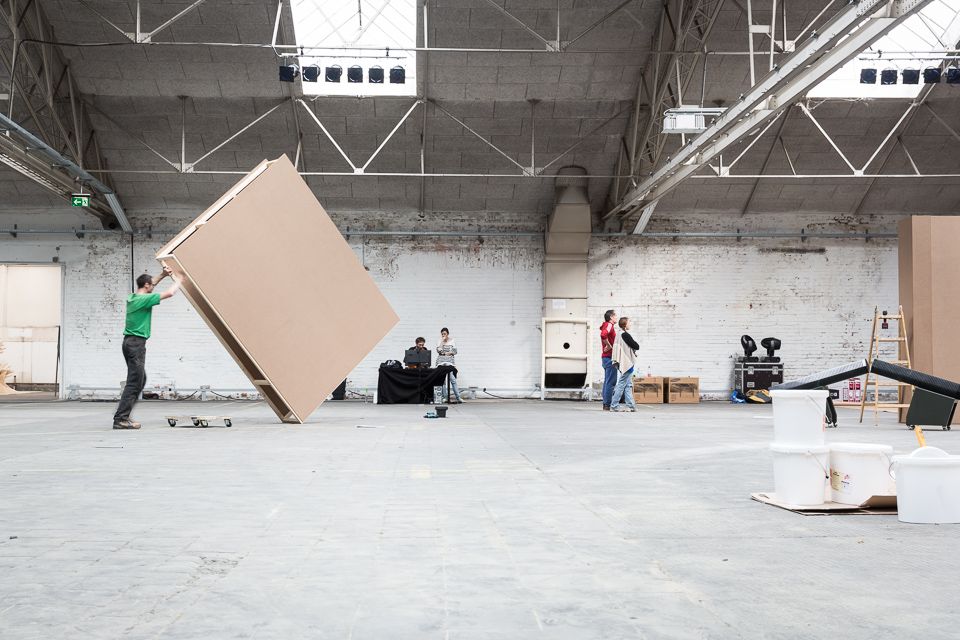 Barrierefreiheit im Kopf 2015: Aufbau: Ein Helfer richtet eine große Stellwand in der leeren Halle auf