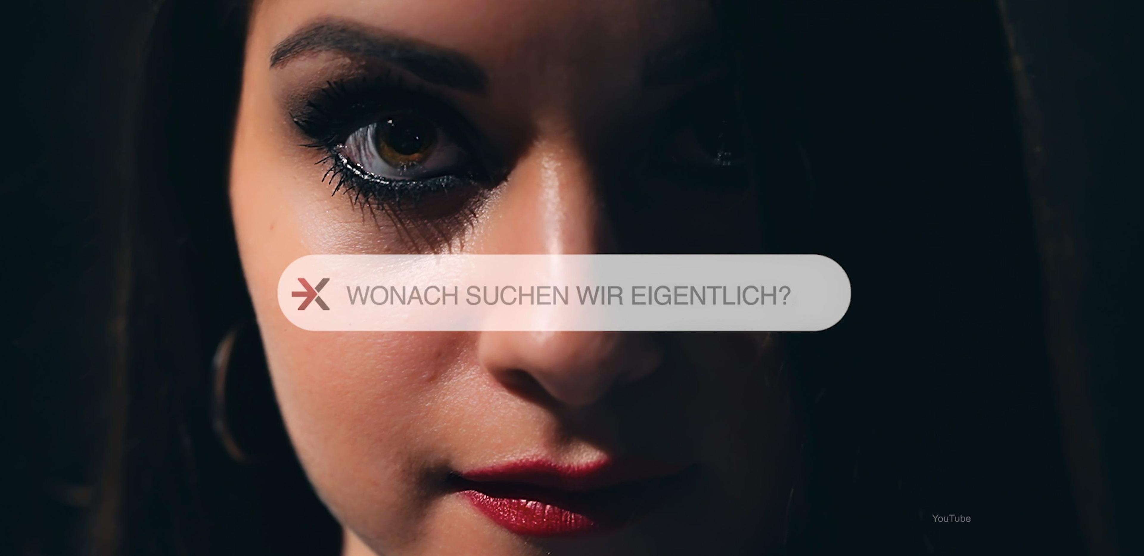 Das Gesicht einer Frau im Hintergrund und davor der Satz: Wonach suchen wir eigentlich