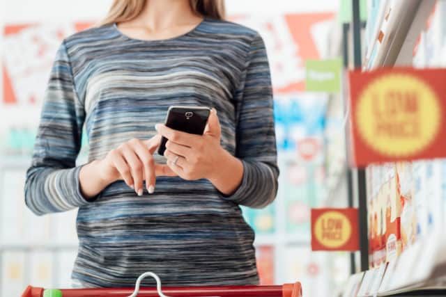 A woman shopping for groceries with the help of a smartphone app