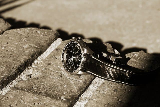A watch laying lost on top of a wall