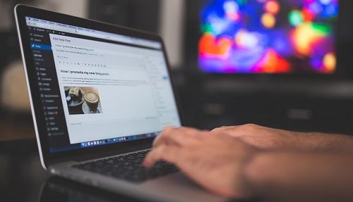 Man writing blog post on his computer