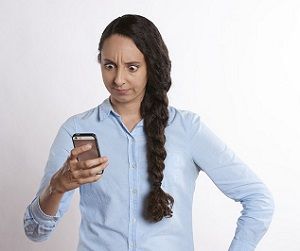 Woman staring at phone, surprised