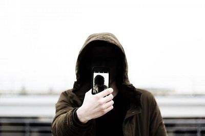 Person in a hoodie taking a picture of themself