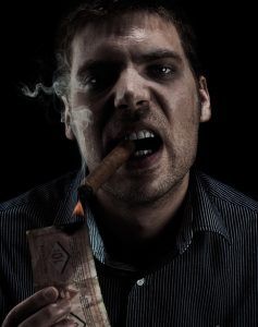 A shadowy figure lighting money on fire with a cigar