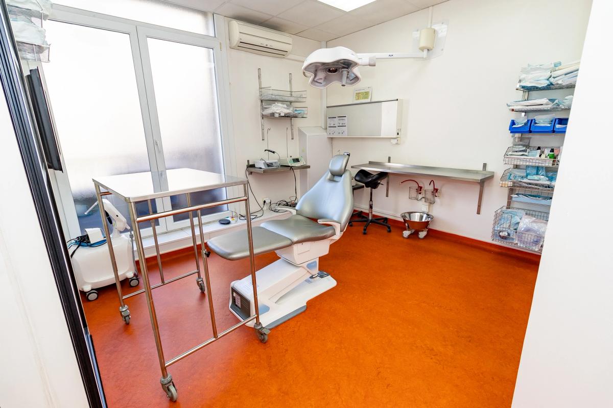 Salle de soins équipée : fauteuil, bras de radiographie et poste de travail