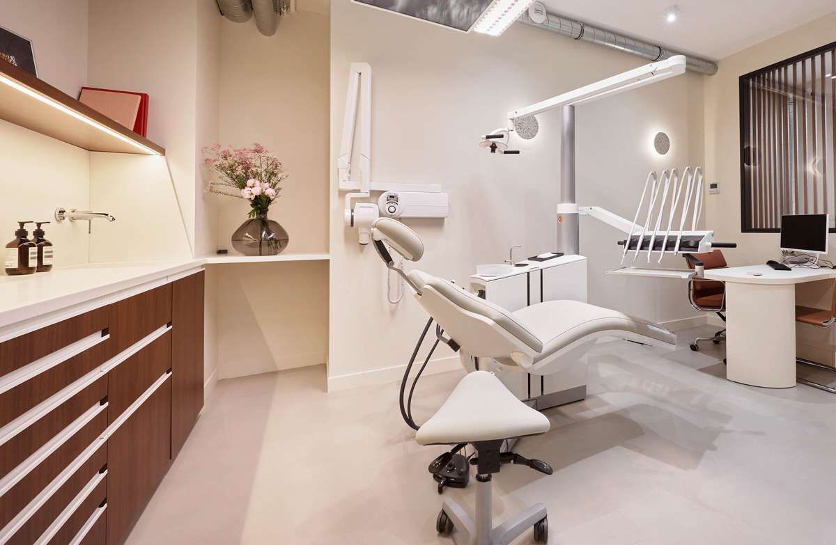 Salle de soins équipée : fauteuil, bras de radiographie et poste de travail