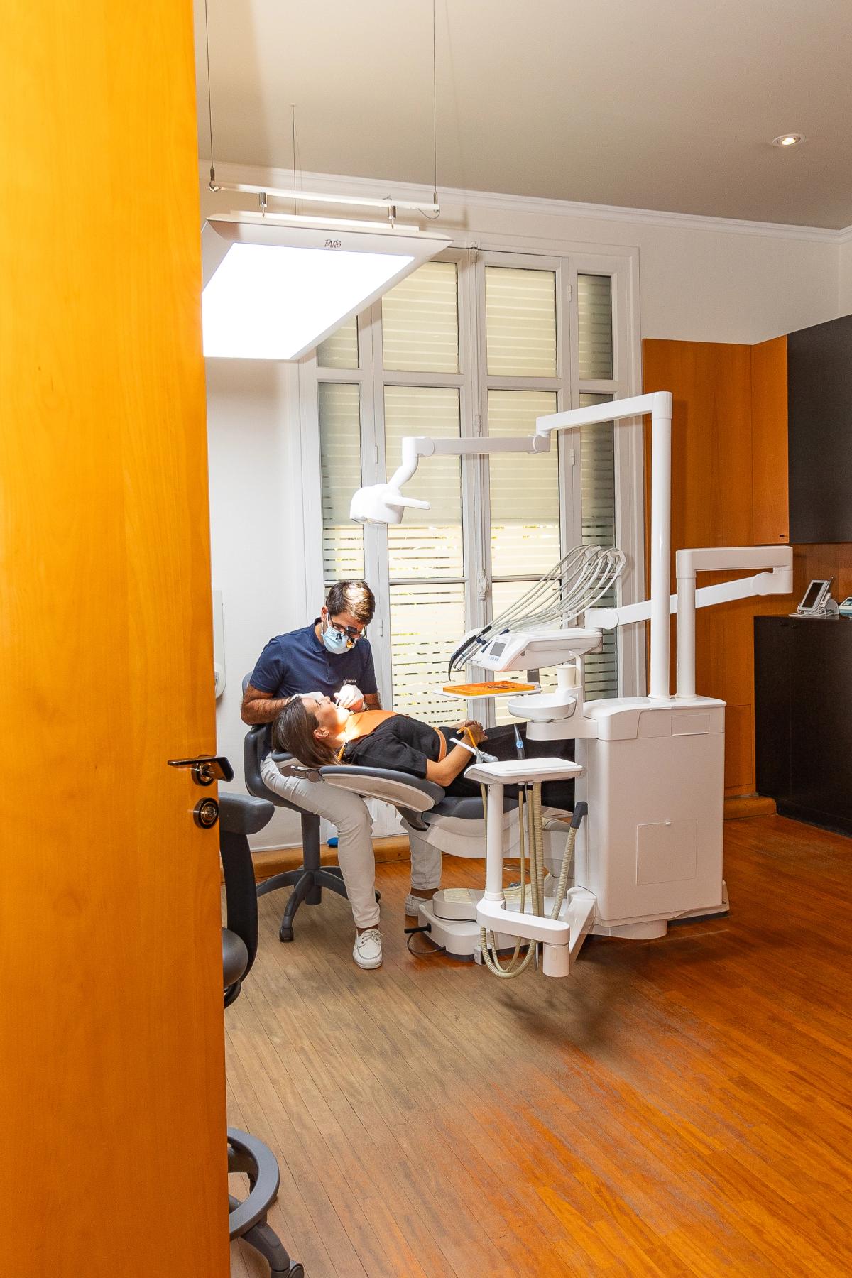 Salle de soins du cabinet, vue depuis le couloir à travers une porte en arche