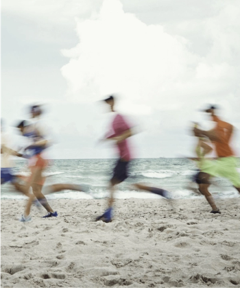 a blurry photo of people running on a beach