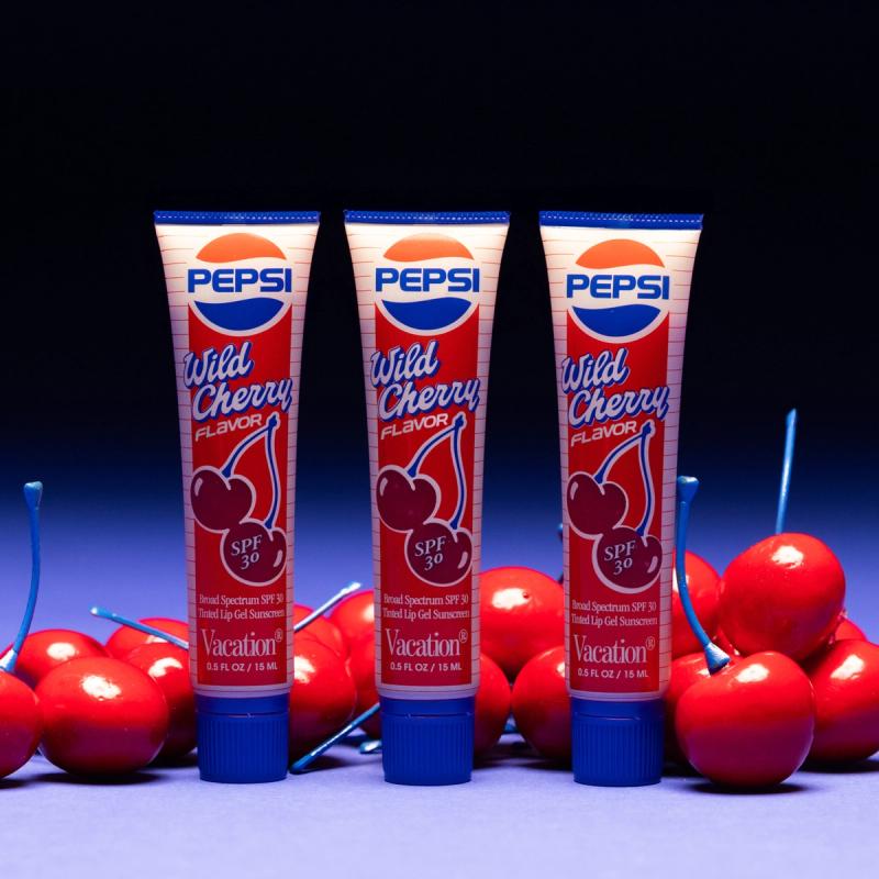 Three tubes of Pepsi® Wild Cherry SPF 30 Lip Gel and a bunch of cherries