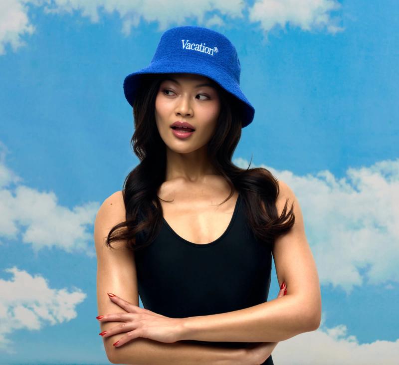 a woman is wearing a blue bucket hat and a black tank top