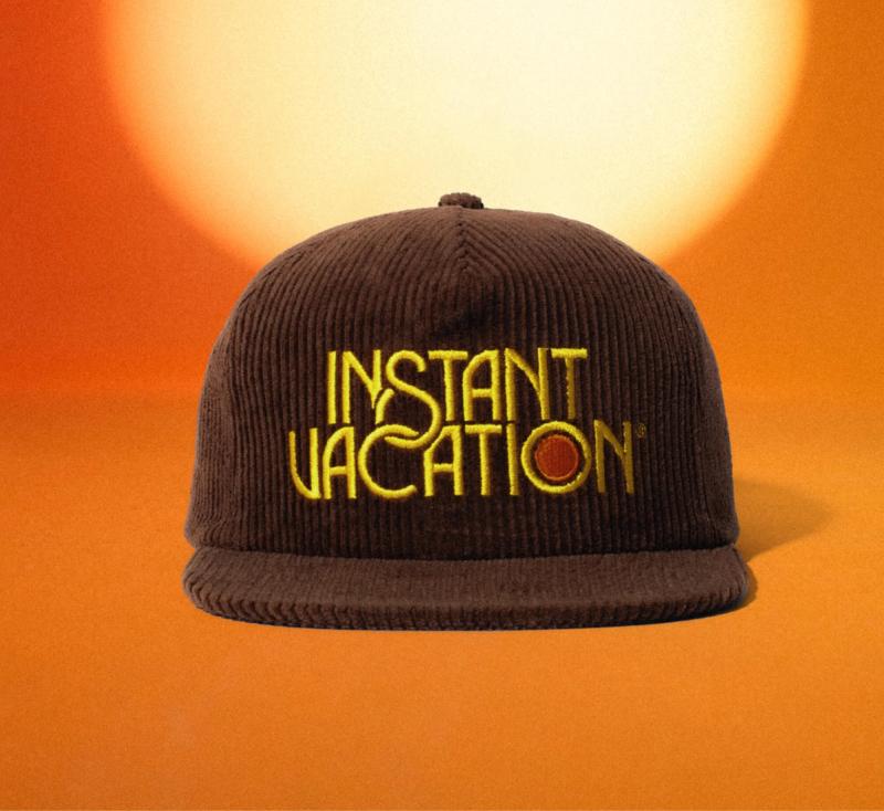 a brown hat with the words `` instant vacation '' embroidered on it .
