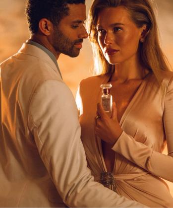 a woman is holding a bottle of tom ford perfume