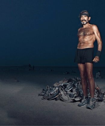 a shirtless man stands in front of a pile of shoes