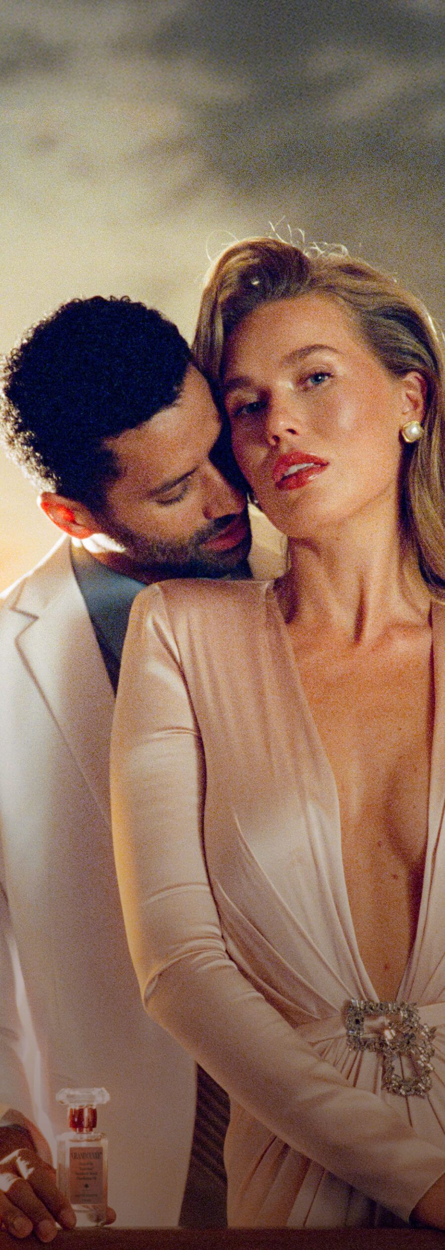 a man is holding a bottle of grand cuvée next to a woman in a dress