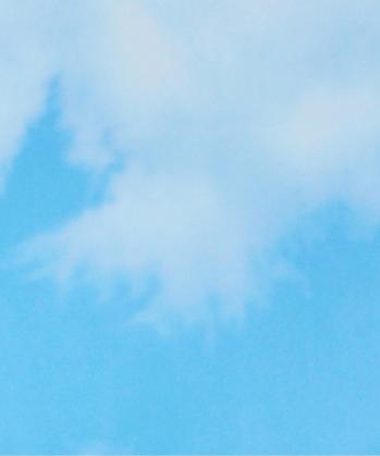 Light blue sky with soft white clouds