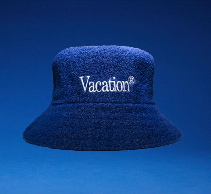 a blue bucket hat with the word vacation embroidered on it .