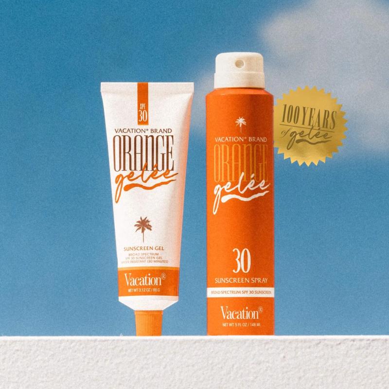 Two Vacation Brand Orange Gelée SPF 30 sunscreens, a white gel tube and an orange spray bottle, against a blue sky with a "100 Years of Gelée" gold seal.