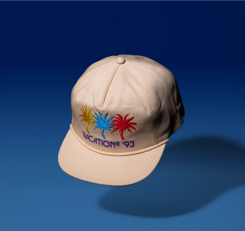 A Vacation® Jazz Palms Rope Hat, with a yellow, blue, and pink palm tree reading "Vacation® '93"