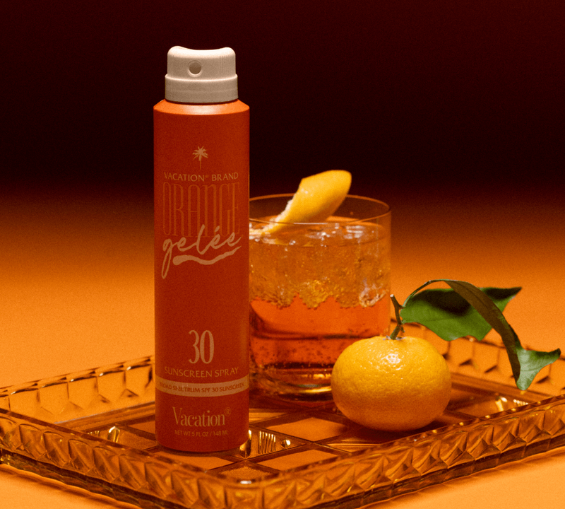 a tray holding Orange Gelée Spray Oil, a cocktail and a satsuma