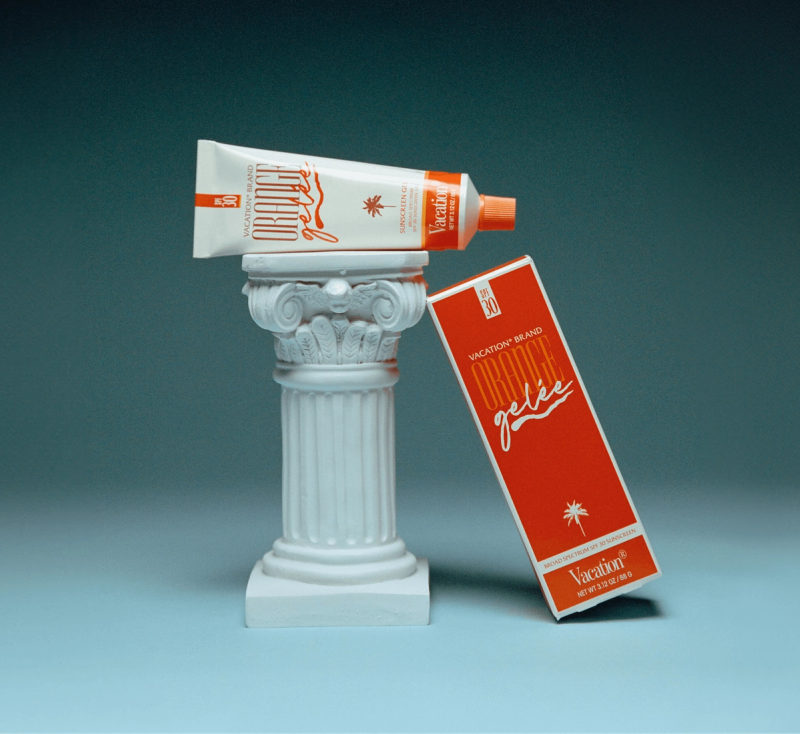 a tube of orange gelee is sitting on top of a white pillar