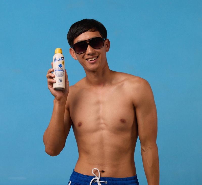a man in swim trunks on a light blue background presenting Classic Spray