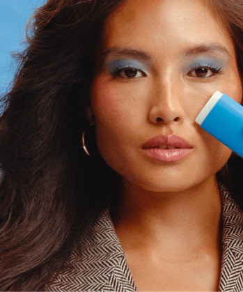 a woman with blue eyeshadow and a blue eraser on her face