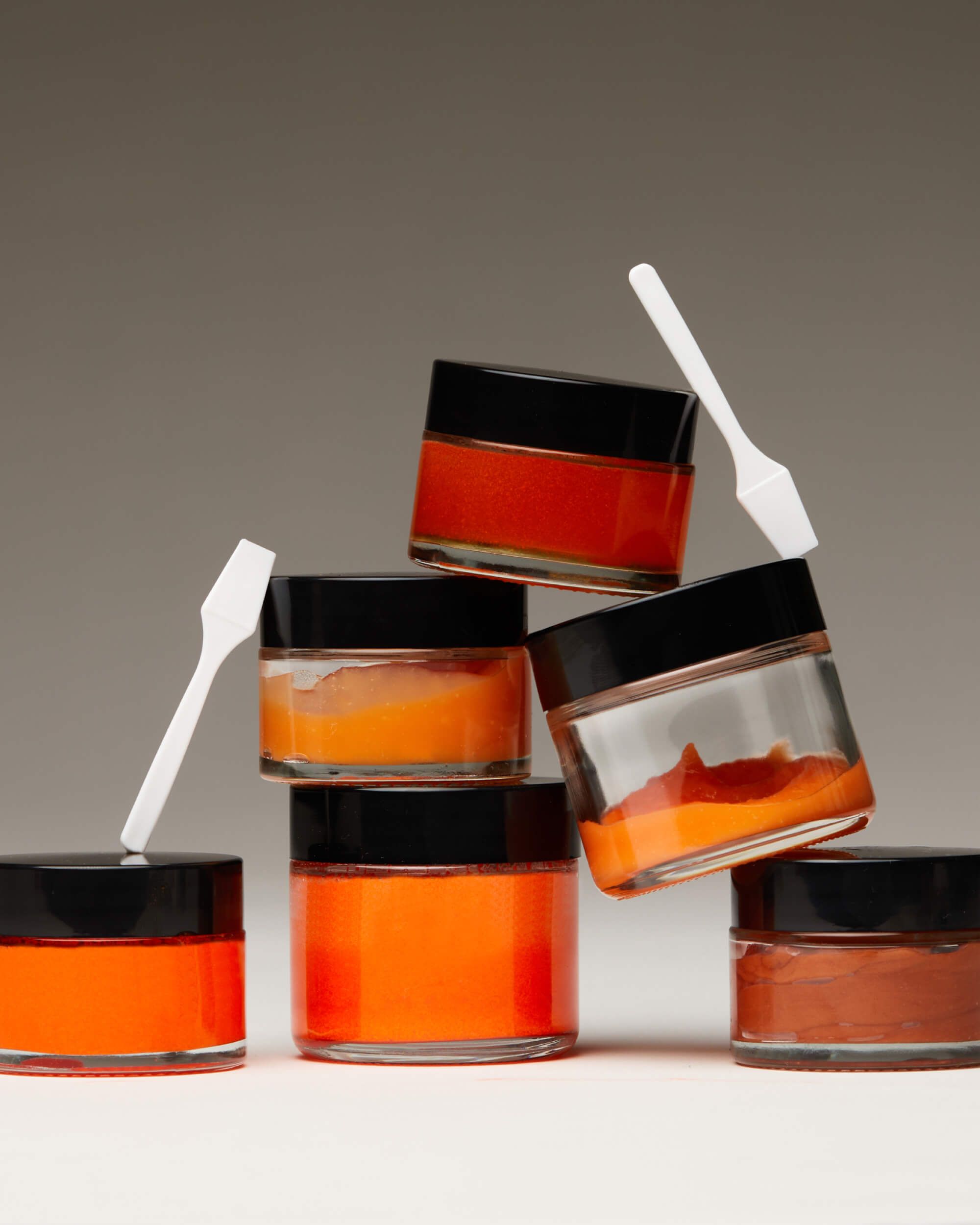 a stack of jars of orange gelée with scoopulas