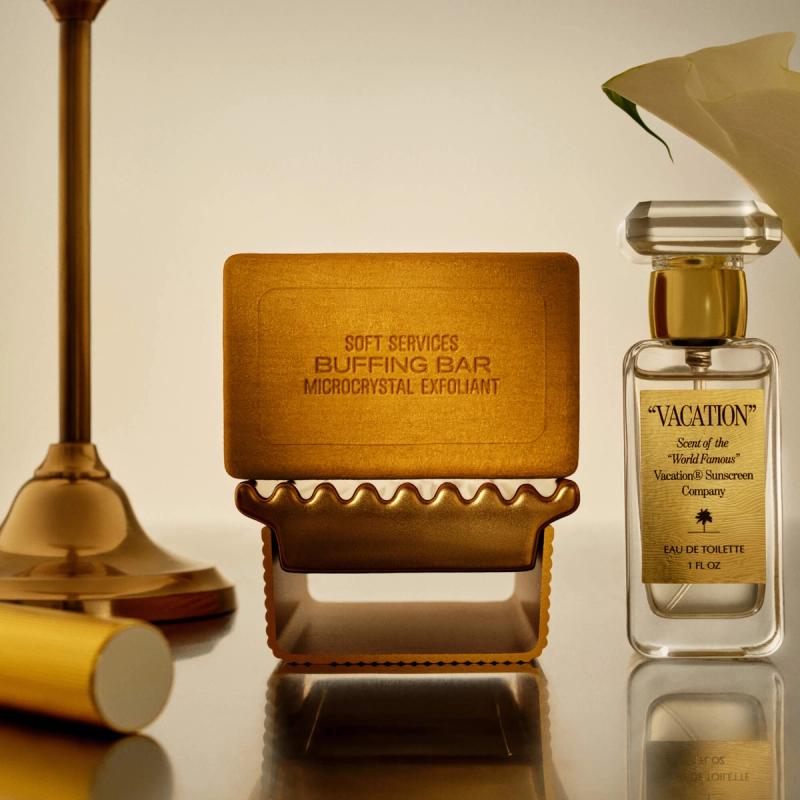 Soft Services Buffing Bar on a gold stand next to a "Vacation" Eau de Toilette bottle.