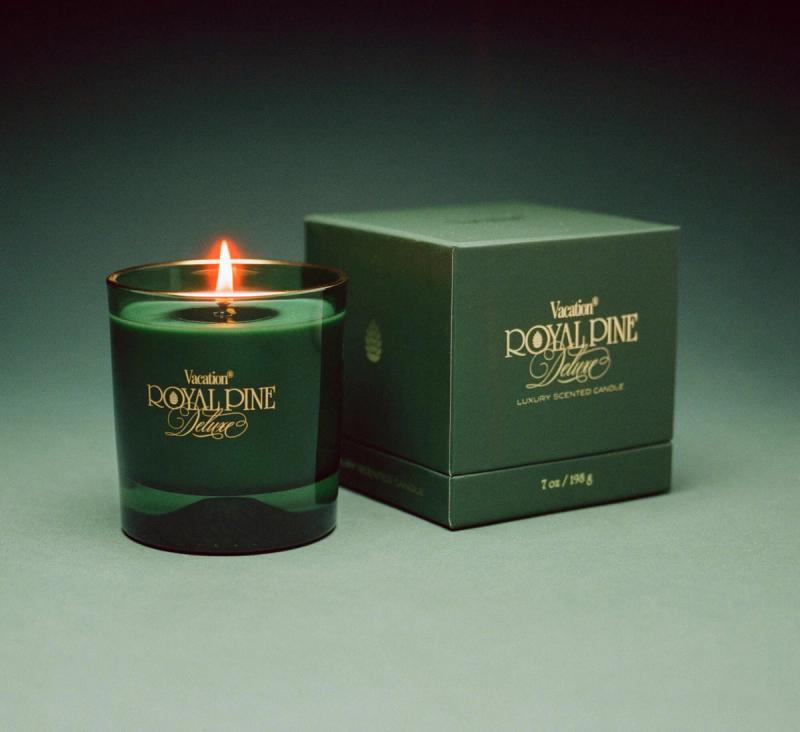 Royal Pine Deluxe, a green glass candle with gold imprint, and premium gift box on a green background