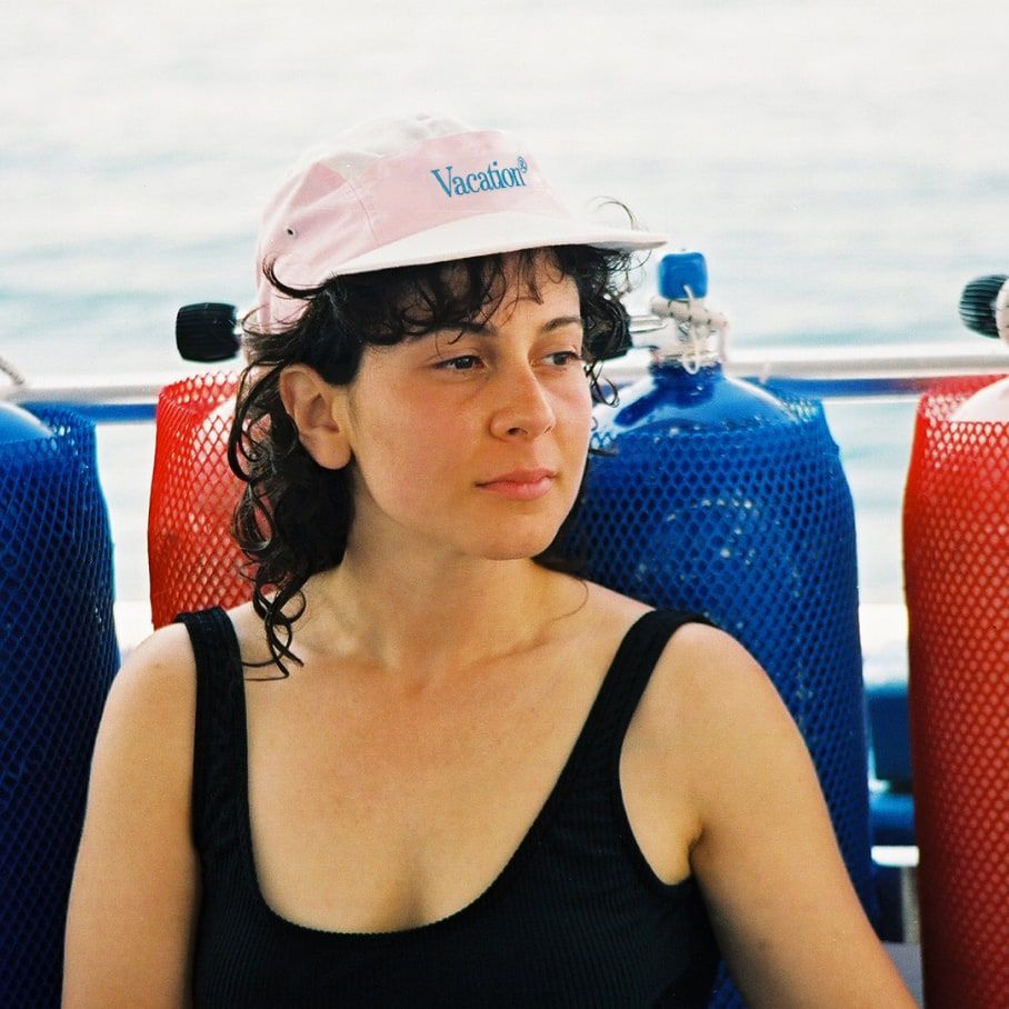 a woman wearing a pink hat that says vacation