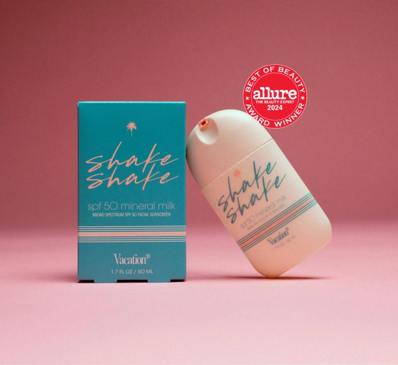 A teal box and a leaning peach bottle of Vacation Shake Shake SPF 50 Mineral Milk sunscreen, with an Allure Best of Beauty 2024 award sticker.