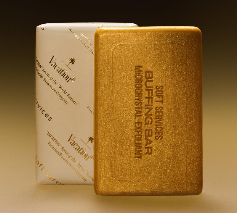 A gold Soft Services Buffing Bar next to a white Vacation branded wrapped bar