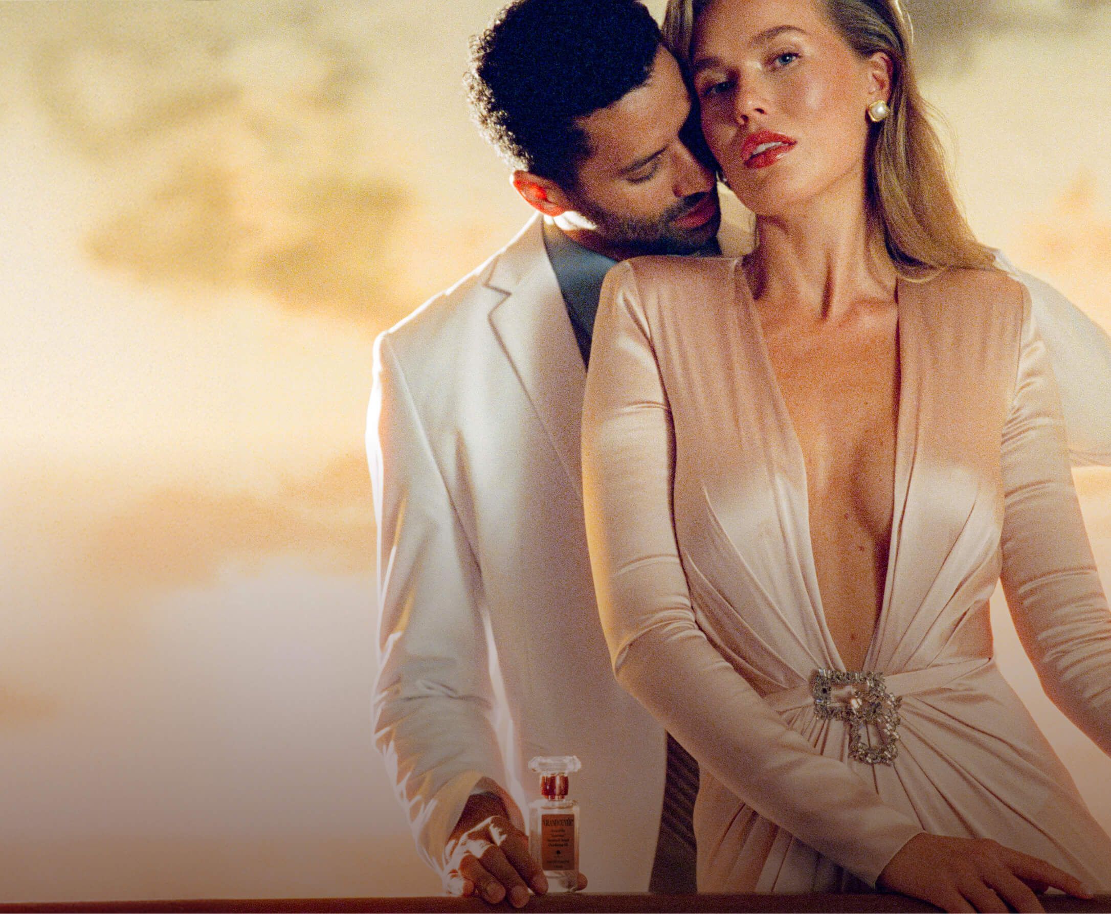 a man is spraying perfume on a woman in a dress .