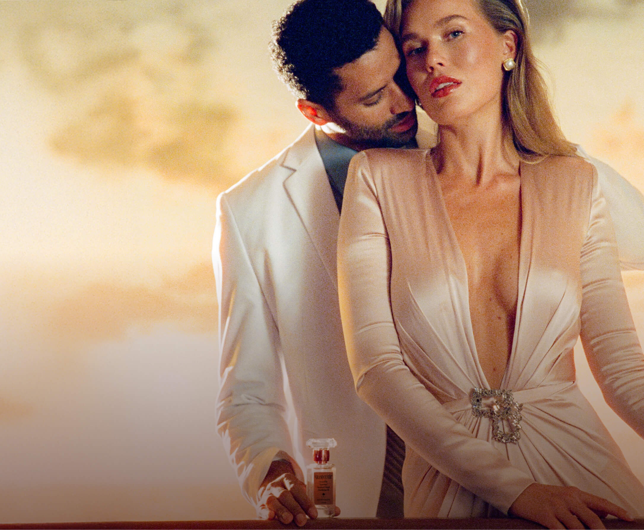 a man is spraying perfume on a woman in a dress .