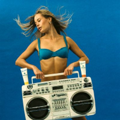 a blonde woman carrying a boombox with sunscreen